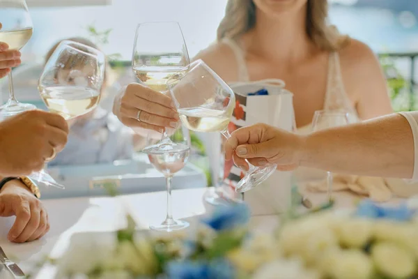 人们在阳台上的桌子上端着酒杯或香槟 主席之友会议 图库照片