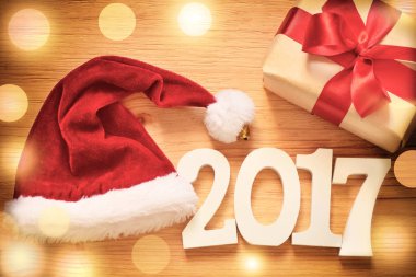 Noel hediyesi kutu ahşap arka plan ve Noel Baba şapkası.