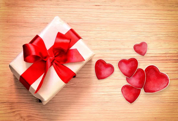 Caja de regalo y corazones sobre fondo de madera . — Foto de Stock