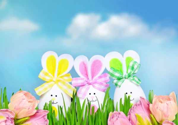 Farbige Ostereier Hase auf grünem Gras und Blumen — Stockfoto