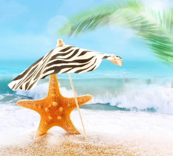Estrella de mar en la playa de arena y sombrilla — Foto de Stock