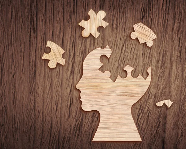 Human head silhouette with a jigsaw piece cut out — Stock Photo, Image