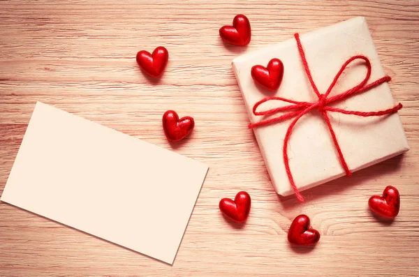 Presentbox med en röda hjärtan på ett gammalt träbord. Alla hjärtans dag. — Stockfoto