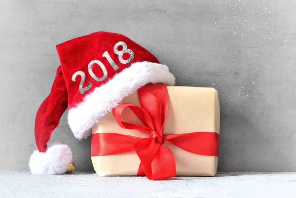 Scatola con regalo di Natale e cappello di Babbo Natale su sfondo grigio — Foto Stock