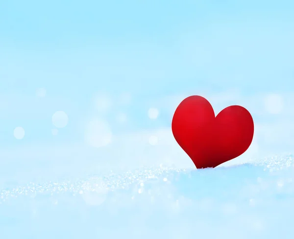 Rött hjärta på en blå snöiga bakgrund. — Stockfoto