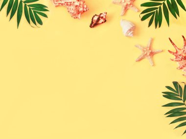 Tropikal arka plan. Palmiye ağaçların dalları ile deniz yıldızı ve Sarı zemin üzerine deniz kabuğu. Seyahat. Kopya alanı.