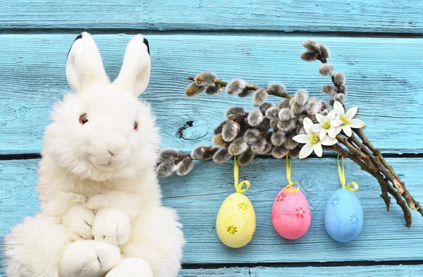 Easter funny bunny on wooden background and easter eggs. Easter background.