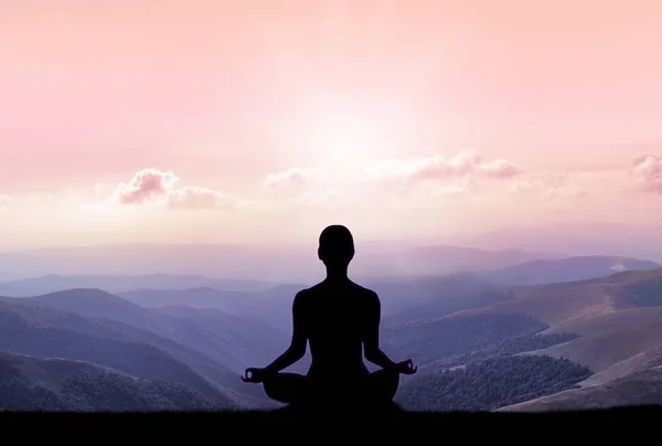 Yoga silhuet på bjerget i solstråler - Stock-foto
