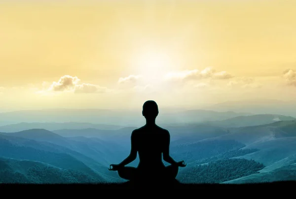 Yoga silhuett på berget i solens strålar — Stockfoto