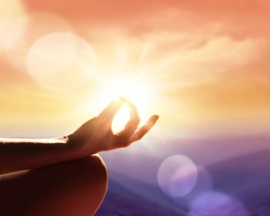 Meditasyon pozunda bir eli yakın tut. Dağlarda gün batımı.
