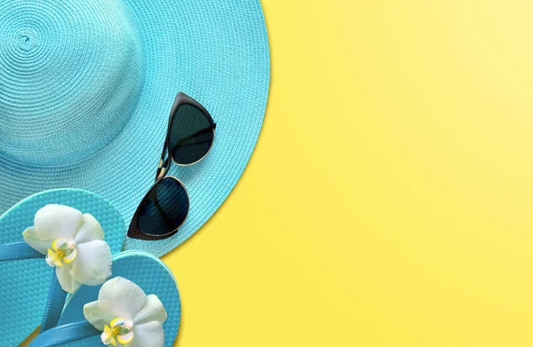 Summer hat with sunglasses. Top view, minimal concept over a yellow background
