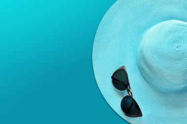 Güneş gözlüklü yaz şapkası. Üst görünüm, mavi arkaplan üzerindeki en küçük konsept