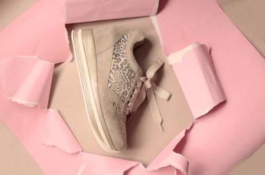 Fotokopi alanı için yırtık delikli pembe kağıt arka planda bej ayakkabılar. Üst Manzara. Minimalizm moda kavramı