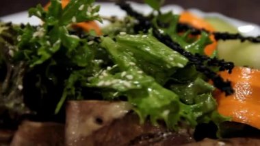 Sebzeli kızarmış et ve tabakta otlar.