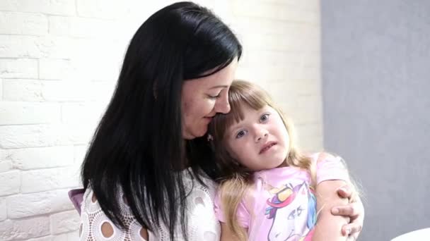 Λυπημένο κορίτσι που κάθεται στην αγκαλιά μιας χαρούμενης μαμάς — Αρχείο Βίντεο