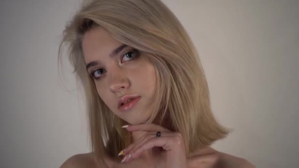 Tajemná mladá blondýnka, holá ramena, podívejte se do kamery — Stock video