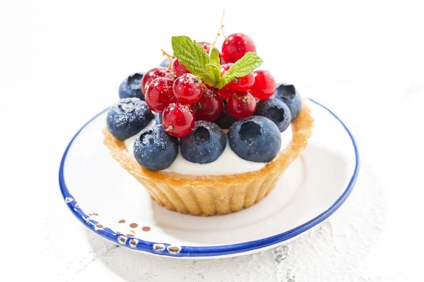 Mini tart with cream and berries on white plate — Stock Photo, Image