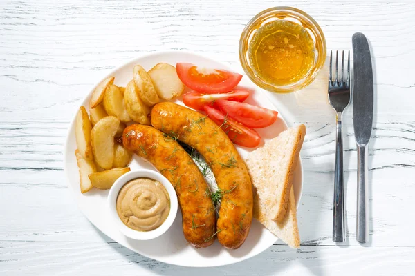 Fried sausages with potatoes, mustard and beer, top view — Stock Photo, Image