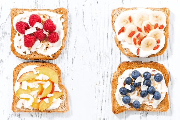 Sladké toasty s různými polevami na bílý dřevěný stůl — Stock fotografie