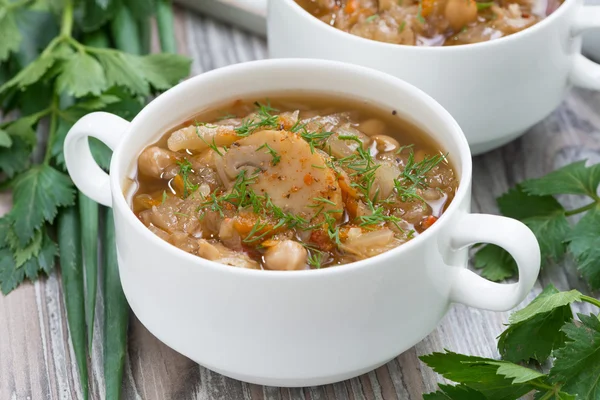 Soup with cabbage, mushrooms and chickpeas on wooden table — Stock Photo, Image