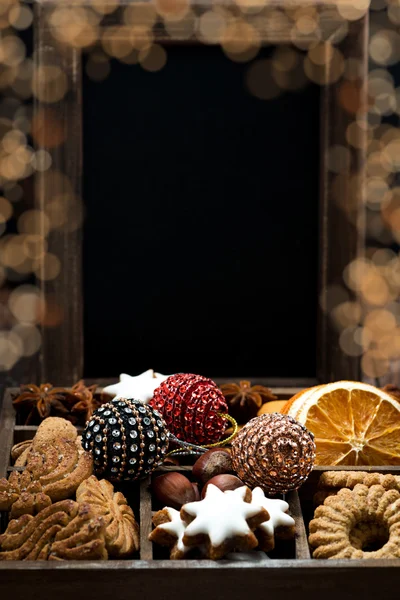 wooden box with Christmas sweets, spices, dark background