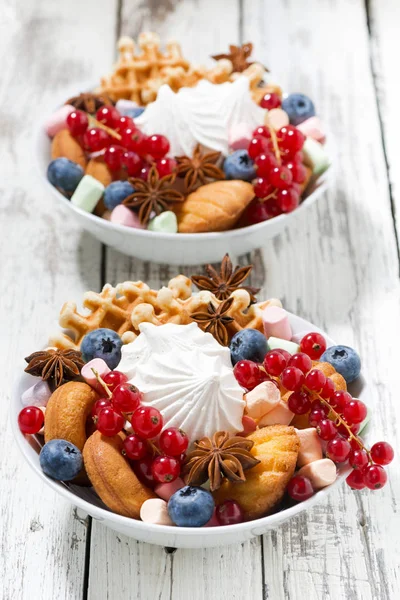 Миска з цукерками та ягодами, вертикальна — стокове фото