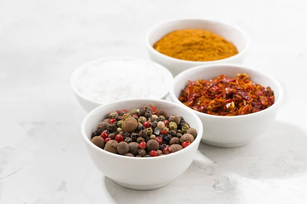 Assortiment van peper, zout en specerijen in kommen — Stockfoto