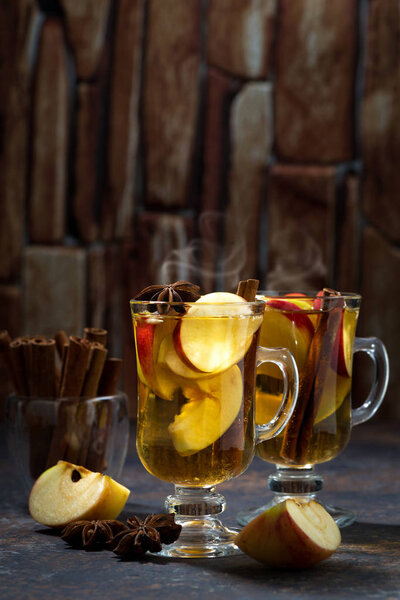 hot apple tea with spices on dark background, vertical