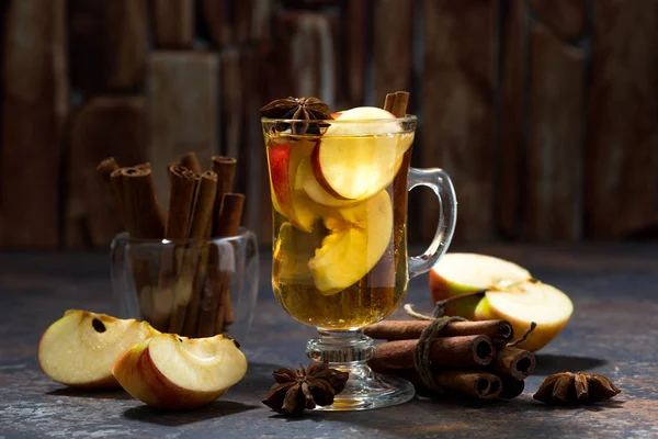 hot apple tea with spices on dark background