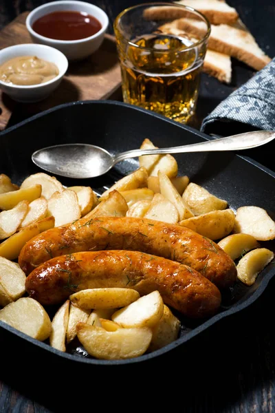 Fried pork sausages with potatoes in frying pan for lunch — Stock Photo, Image