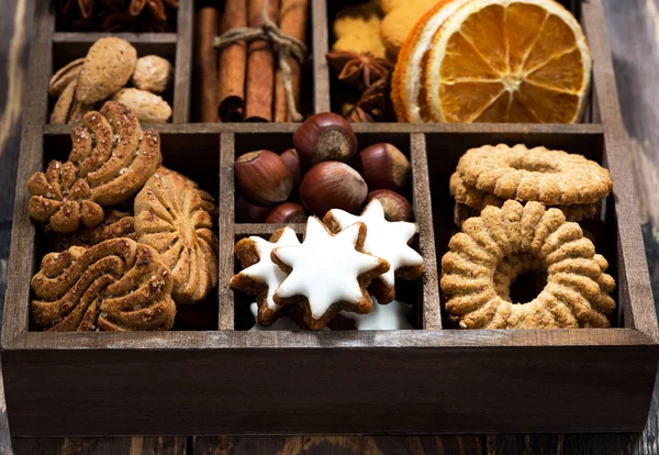 wooden box with Christmas sweets and spices on wooden table