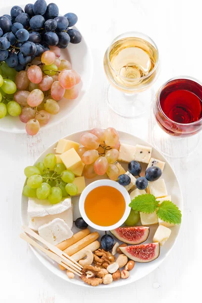 Käse, Obst, Wein und Snacks auf dem Teller, von oben — Stockfoto