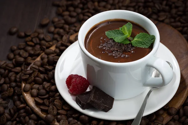 Chocolate quente com sabor em uma xícara em um fundo de grãos de café — Fotografia de Stock