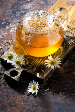 koyu arka plan üzerinde cam çaydanlık kokulu papatya çayı