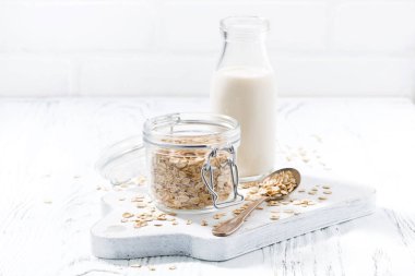 yulaf gevreği ve şişe süt beyaz ahşap zemin üzerinde