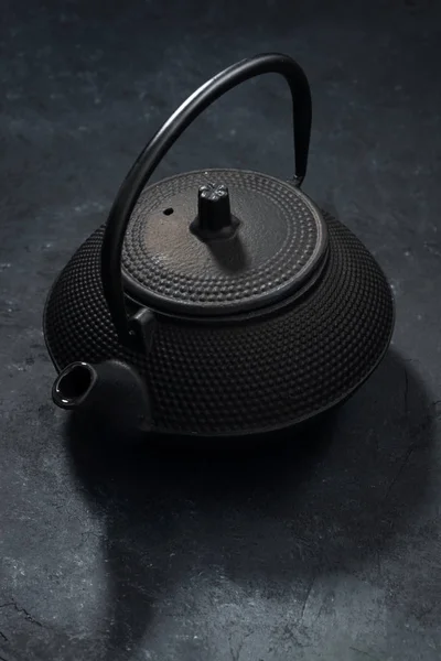 Schwarze Teekanne aus Eisen auf dunklem Hintergrund — Stockfoto