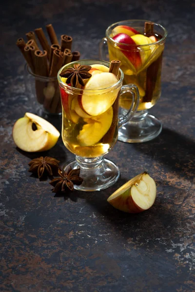 Copos de chá de maçã quente com especiarias na mesa escura, vertical — Fotografia de Stock