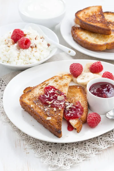 Desayuno dulce - tostadas crujientes con frambuesas, plátano y mermelada — Foto de stock gratuita