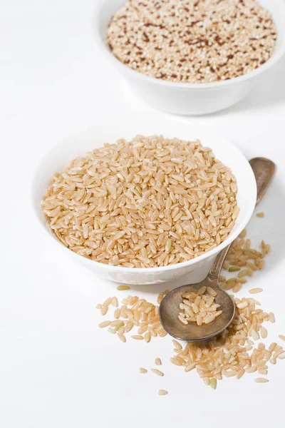 Kahverengi pirinç ve quinoa bir kase beyaz bir arka planda, dikey — Stok fotoğraf