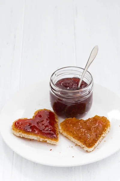 Two toasts in heart shape with fruit jams, vertical — Stock Photo, Image
