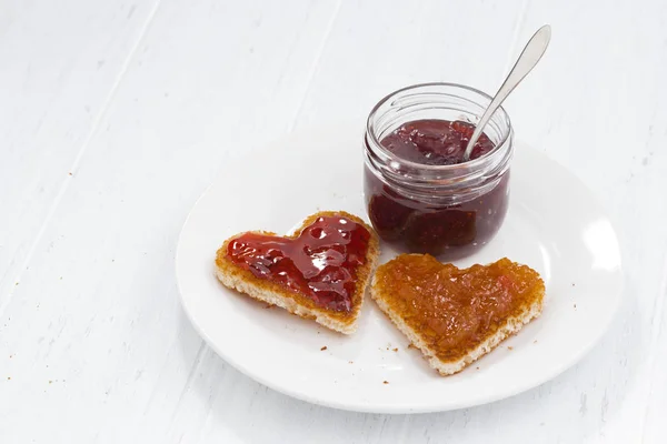 Two toasts in heart shape with fruit jams — Stock Photo, Image