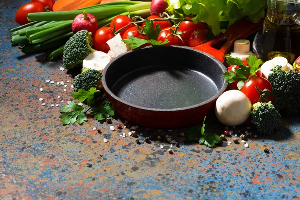 Frigideira de ferro fundido vazia e legumes orgânicos frescos — Fotografia de Stock
