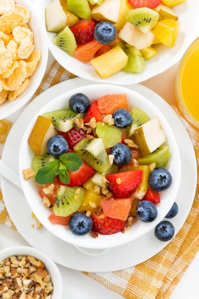 Petit déjeuner avec salade de fruits et flocons de maïs sur la table, vertical — Photo