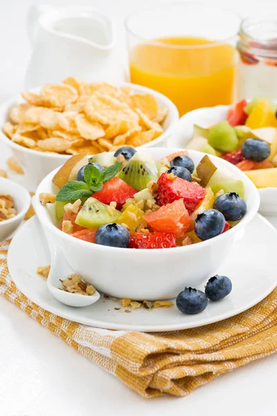 Frühstück mit Obstsalat und Cornflakes auf dem Tisch, senkrecht — Stockfoto