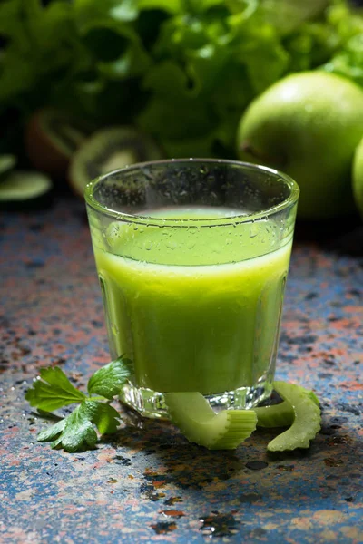 Verre de jus de céleri et de légumes sur fond bleu, vertical — Photo