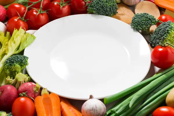 Background white plate and organic vegetables — Stock Photo, Image