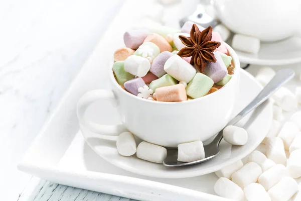 Какао с цветными зефирами и специями в белых чашках — стоковое фото