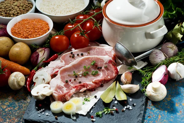 Two pieces of raw pork and fresh ingredients for preparation — Stock Photo, Image