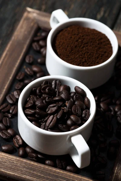 Kaffe och kaffebönor i koppar, vertikala närbild — Stockfoto