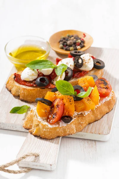 Italian appetizer - bruschetta on wooden board, closeup — Stock Photo, Image